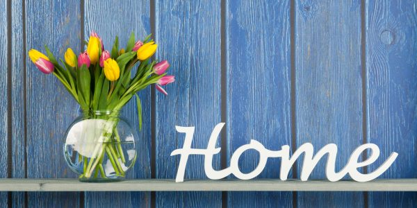 Home in white letters with colorful bouquet tulips in pink and yellow isolated on background